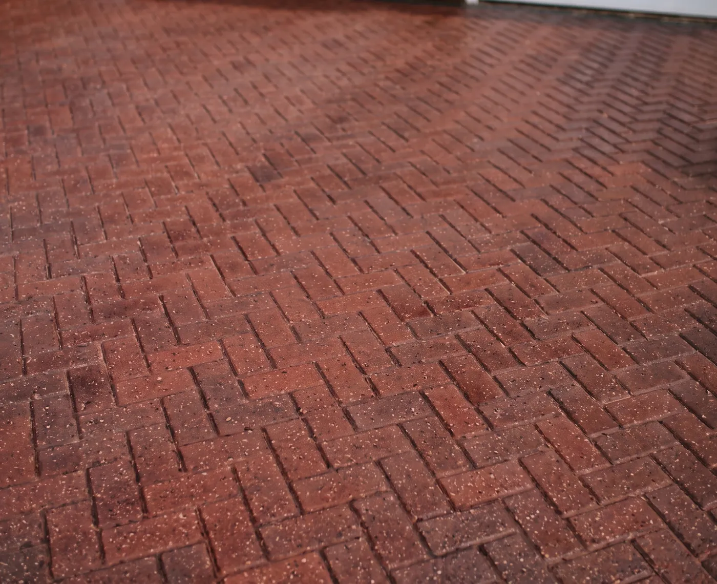 Block paving driveway freshly power washed, herringbone brick restored to a rich red