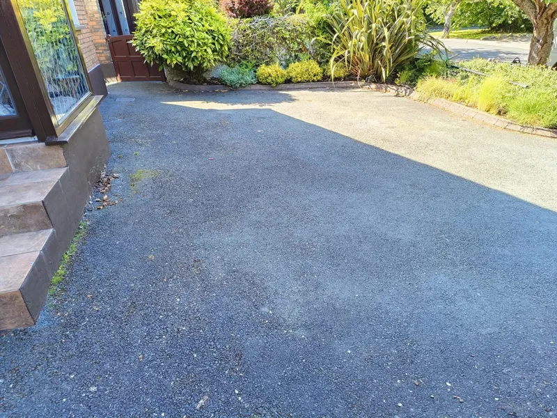 Tarmac before — faded and patchy, with moss by the steps