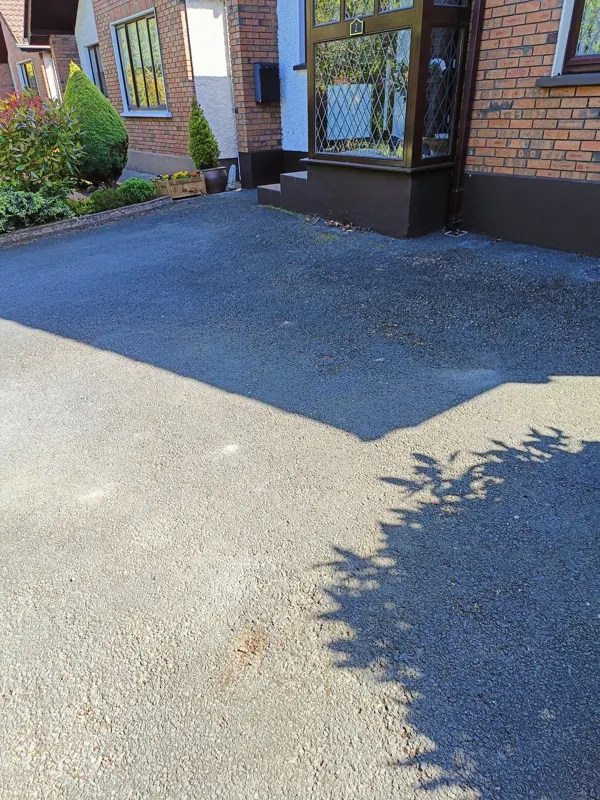 Before — tarmac bleached grey where the sun hits it