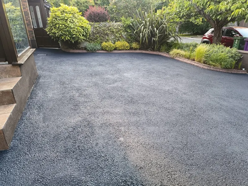 Tarmac after — restored to a deep black up to the garden edging